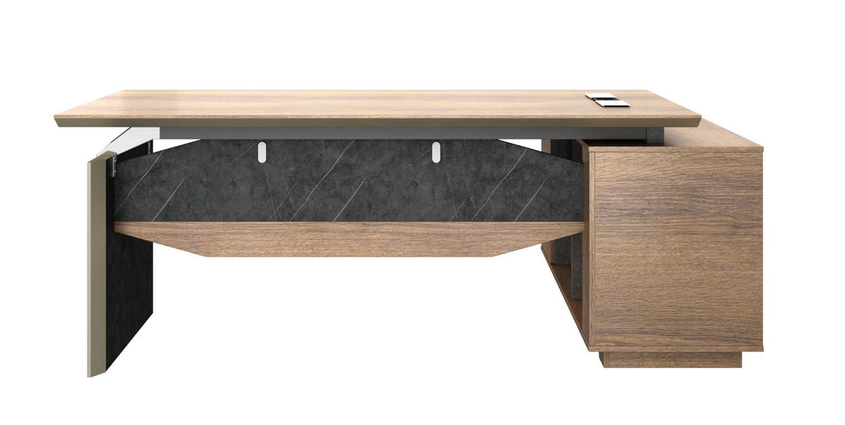 Executive office desk with return in brown oak color, featuring a desktop thickness of 4cm, metal handles and cable management system, set against a bookcase background.